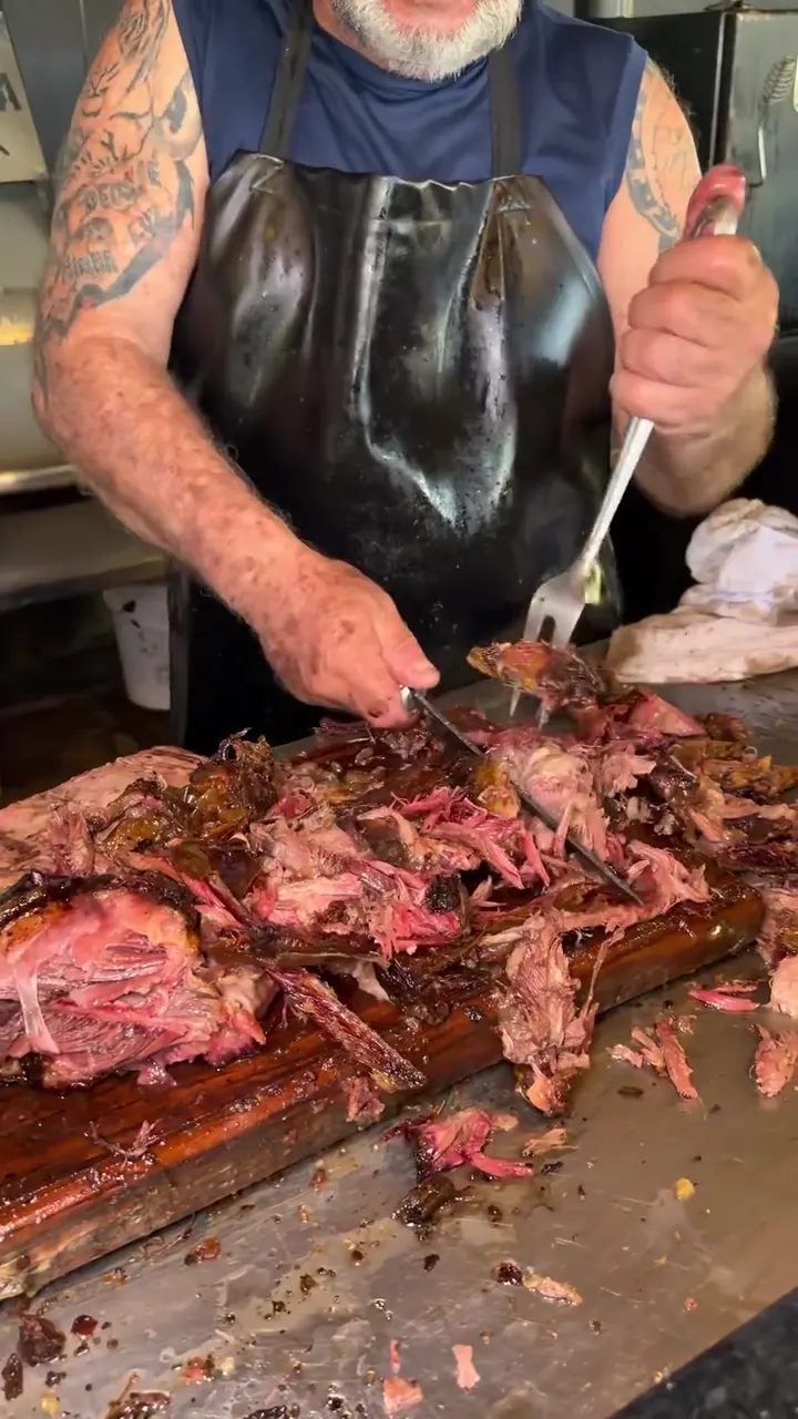 Churrasqueiro cortando a costela fogo de chão